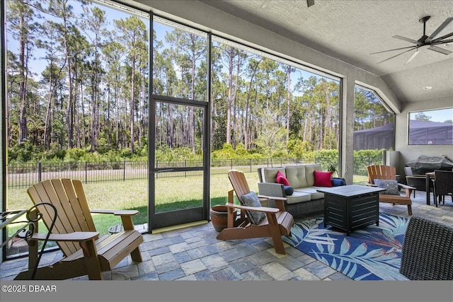 sunroom featuring an outdoor living space and a ceiling fan