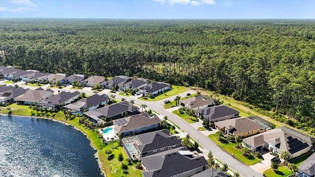 aerial view with a water view, a view of trees, and a residential view