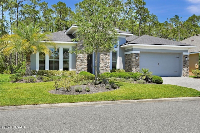 view of front facade with stone siding, a front yard, stucco siding, an attached garage, and driveway