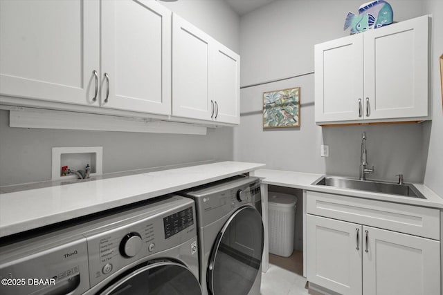 laundry room featuring independent washer and dryer, a sink, and cabinet space