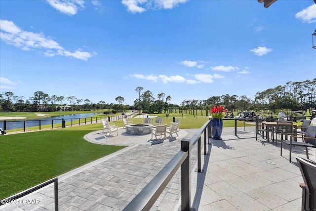 view of patio / terrace featuring a water view, fence, and an outdoor fire pit