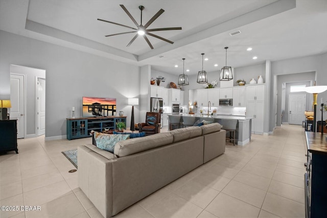 living area with visible vents, ceiling fan, recessed lighting, a raised ceiling, and light tile patterned floors