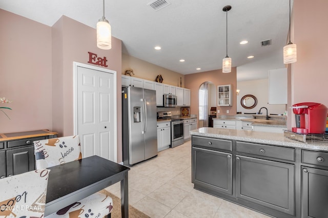 kitchen with light tile patterned flooring, gray cabinetry, tasteful backsplash, decorative light fixtures, and appliances with stainless steel finishes