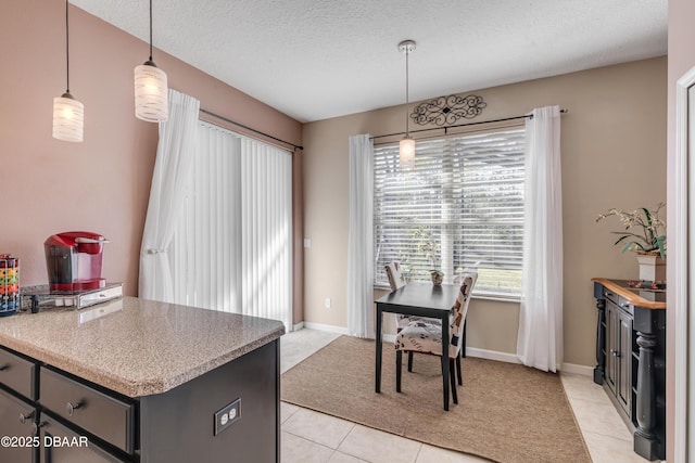 kitchen with light tile patterned floors, hanging light fixtures, and a textured ceiling