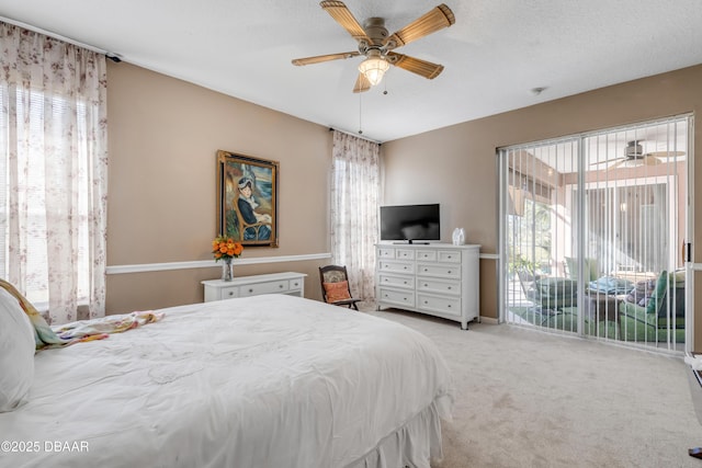 bedroom with multiple windows, access to exterior, light colored carpet, and ceiling fan