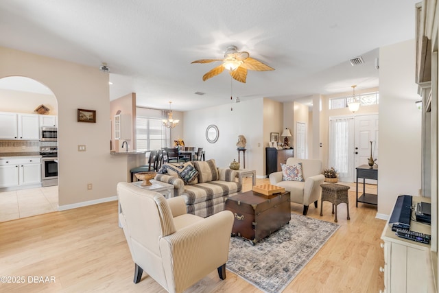 living room with ceiling fan and light hardwood / wood-style flooring