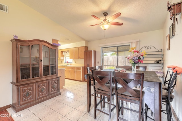 dining area featuring a textured ceiling, vaulted ceiling, visible vents, a ceiling fan, and light tile patterned floors
