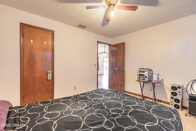 carpeted bedroom featuring visible vents, a textured ceiling, and ceiling fan