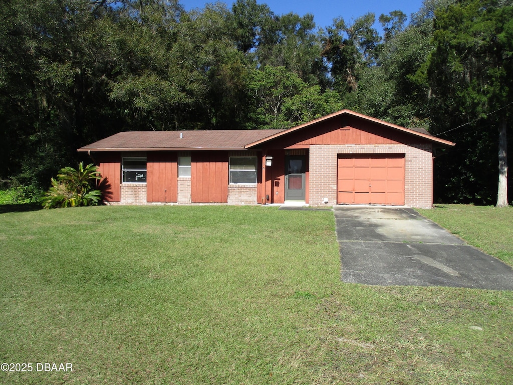 single story home featuring a garage and a front yard