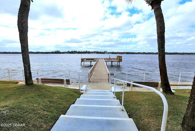 dock area with a yard and a water view