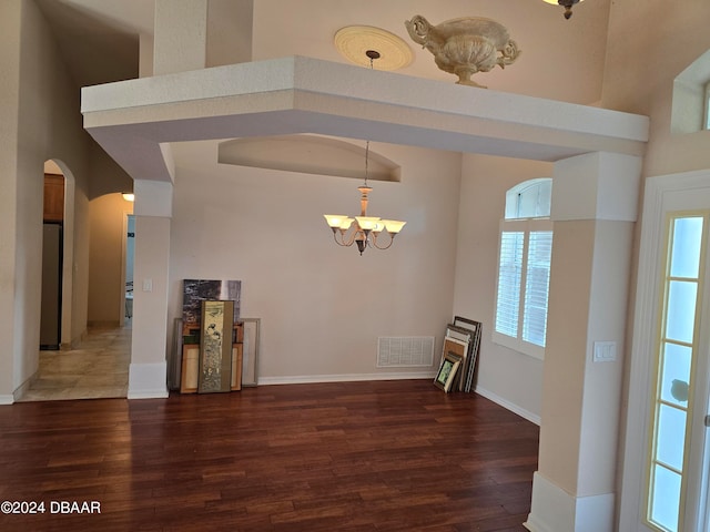 interior space with dark hardwood / wood-style floors, a high ceiling, and an inviting chandelier