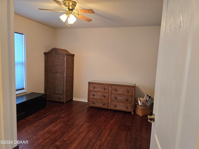 unfurnished bedroom featuring ceiling fan and dark wood-type flooring