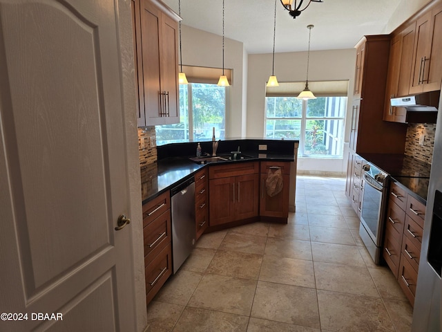 kitchen with backsplash, sink, hanging light fixtures, and stainless steel appliances