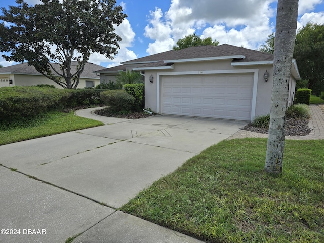 view of front of home with a shingled roof, concrete driveway, an attached garage, and stucco siding