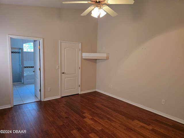 empty room with ceiling fan, dark hardwood / wood-style flooring, and vaulted ceiling