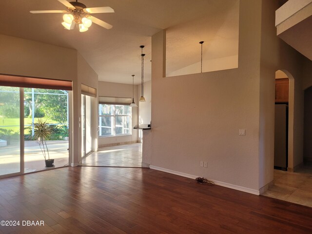 unfurnished living room with lofted ceiling, ceiling fan, and dark hardwood / wood-style floors