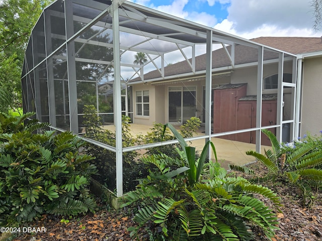 exterior space featuring glass enclosure and a patio