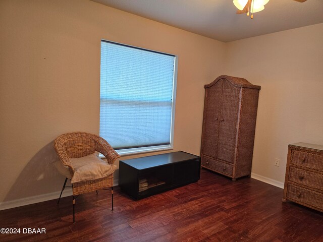 living area featuring ceiling fan and dark hardwood / wood-style floors