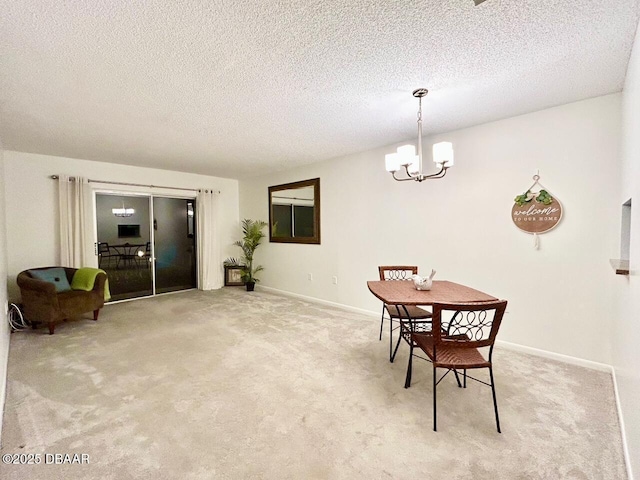 dining space featuring light carpet, a textured ceiling, and a chandelier