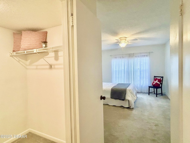 bedroom with ceiling fan, a textured ceiling, and carpet