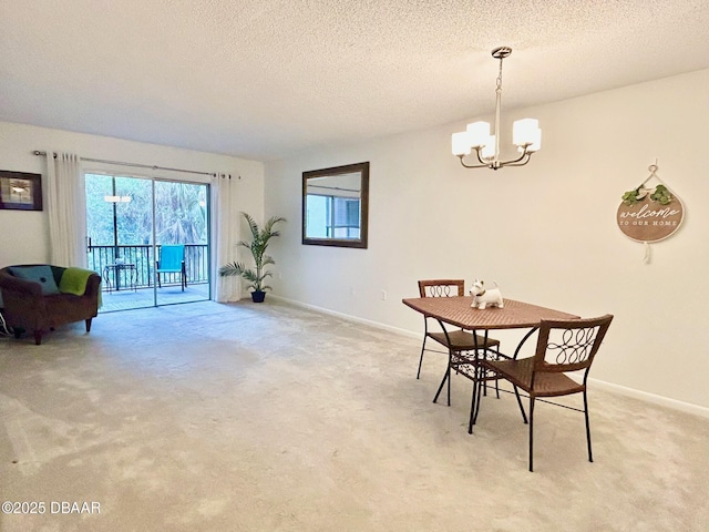 dining room featuring light colored carpet, a notable chandelier, and a textured ceiling