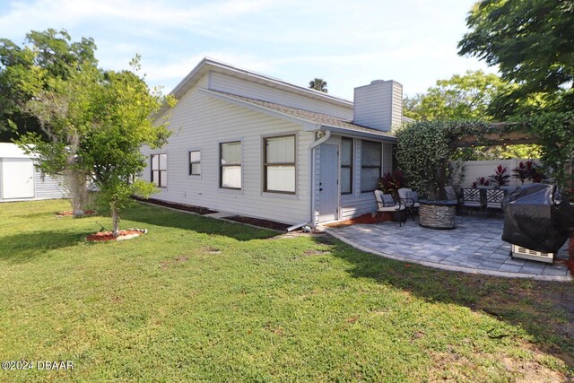 rear view of house with a yard and a patio area