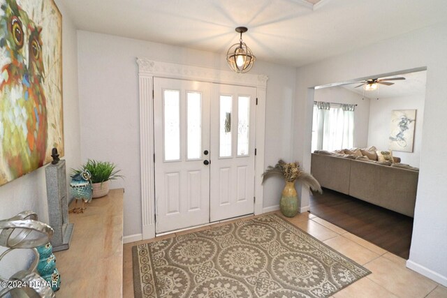 foyer entrance with light tile patterned floors and ceiling fan