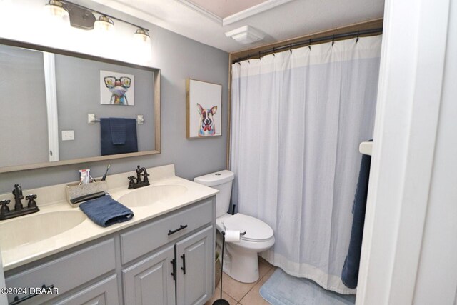 bathroom with toilet, vanity, and tile patterned flooring