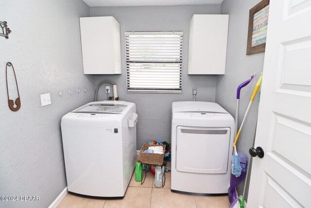 washroom featuring cabinets, light tile patterned floors, and separate washer and dryer