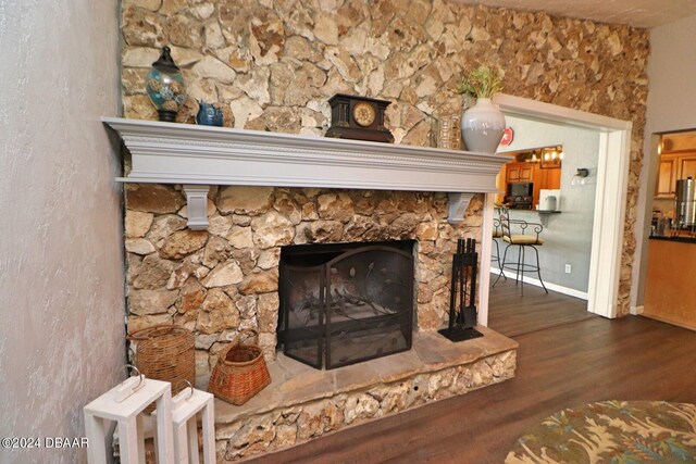 details featuring a fireplace, wood-type flooring, and stainless steel fridge