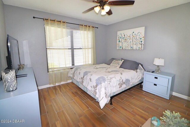 bedroom with dark hardwood / wood-style flooring and ceiling fan