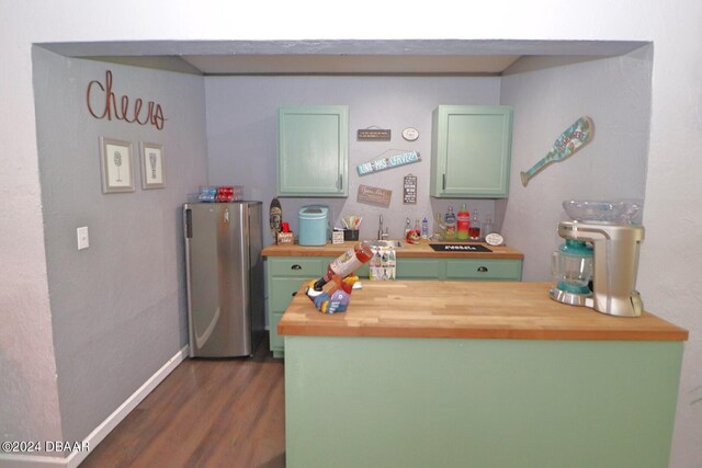 interior space featuring dark hardwood / wood-style flooring, wooden counters, sink, and stainless steel refrigerator