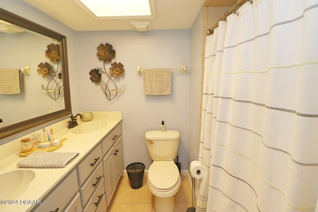 bathroom with toilet, vanity, and tile patterned flooring