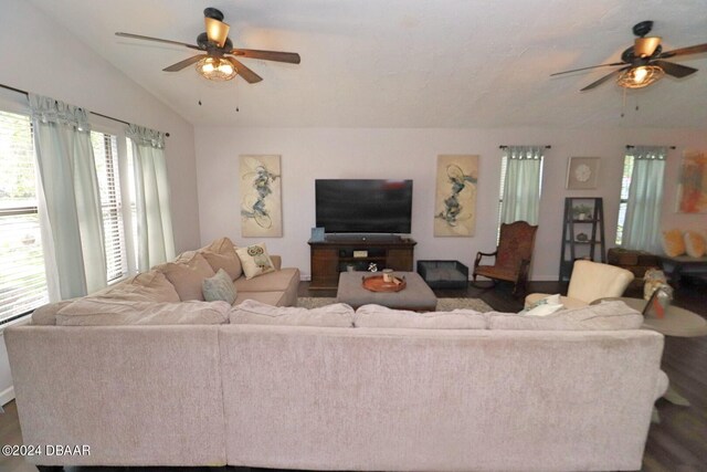 living room featuring dark hardwood / wood-style flooring, lofted ceiling, and ceiling fan