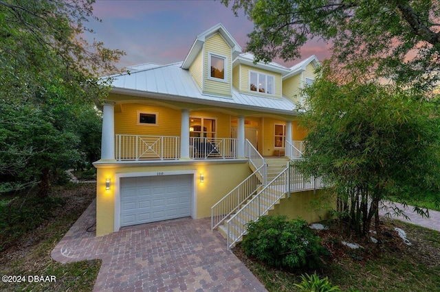 110 Ocean Way Dr, Ponce Inlet, FL 32127 - coastal inspired home featuring covered porch, a standing seam roof, an attached garage, metal roof, and decorative driveway