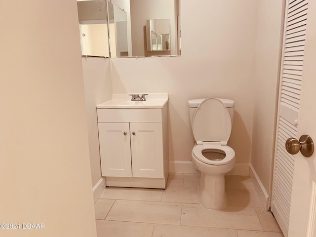 bathroom featuring toilet, vanity, and tile patterned flooring