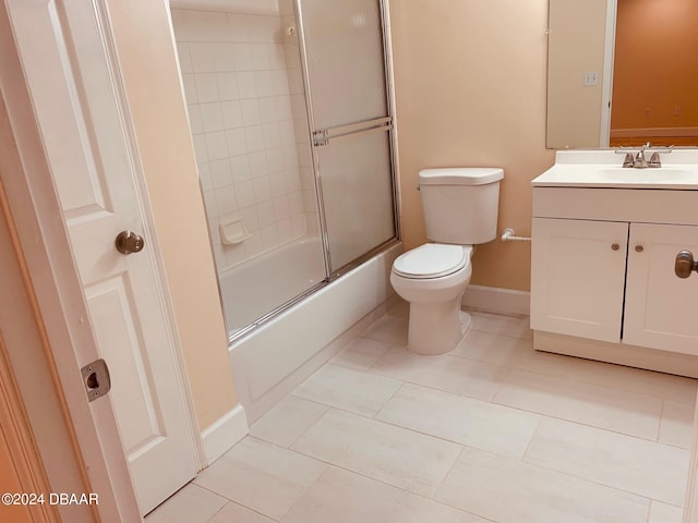 full bathroom with vanity, tile patterned floors, combined bath / shower with glass door, and toilet