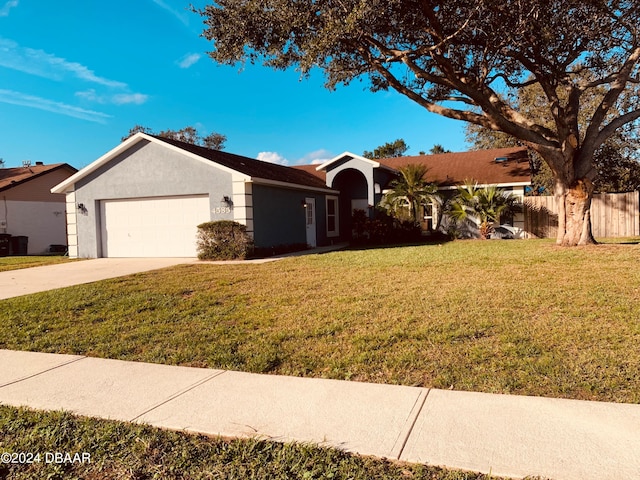 single story home featuring a garage and a front lawn