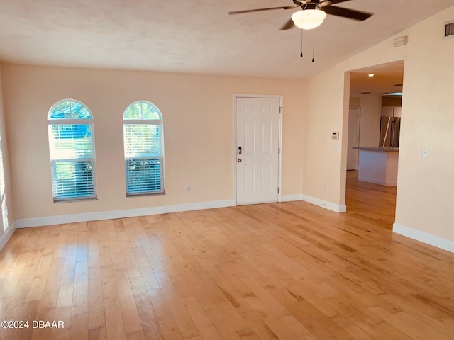 empty room featuring light hardwood / wood-style floors, ceiling fan, and vaulted ceiling