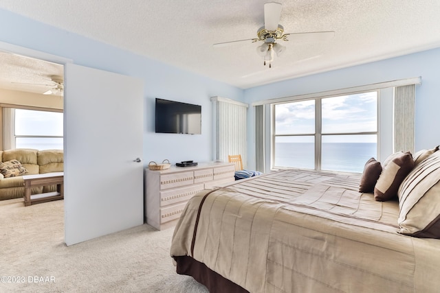 1183 Ocean Shore Blvd Unit 5050, Ormond Beach, FL 32176 - bedroom featuring light carpet, multiple windows, a textured ceiling, and a ceiling fan