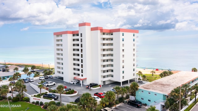 view of building exterior featuring a water view and a beach view