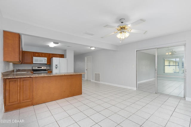 kitchen with white appliances, light stone countertops, kitchen peninsula, and ceiling fan