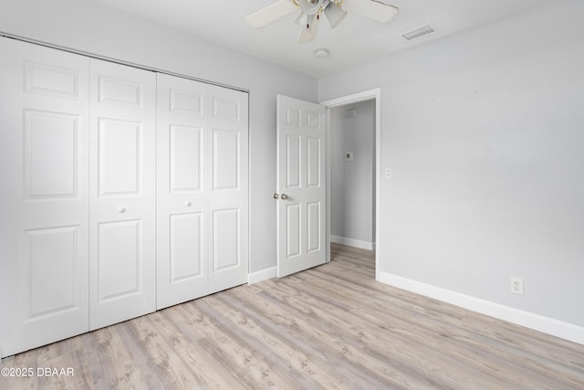 unfurnished bedroom with ceiling fan, light wood-type flooring, and a closet