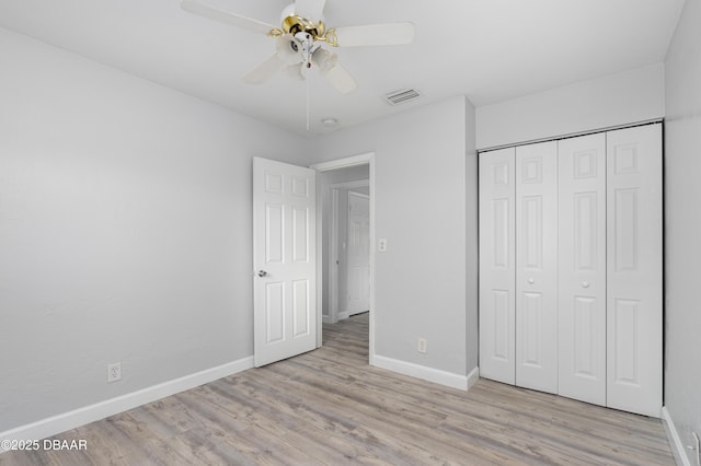 unfurnished bedroom featuring light hardwood / wood-style floors, a closet, and ceiling fan