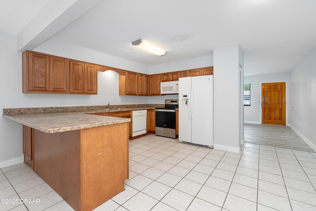 kitchen with sink, light tile patterned floors, white appliances, and kitchen peninsula