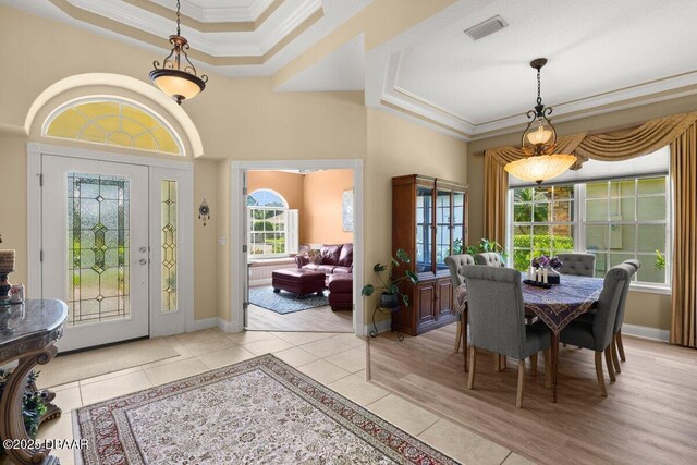 3428 Rexford Cir, Ormond Beach, FL 32174 - dining area featuring ornamental molding, a tray ceiling, light tile patterned flooring, and baseboards