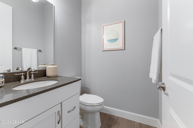 bathroom featuring hardwood / wood-style floors, vanity, and toilet