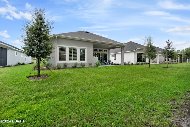 back of house with a yard and a patio area