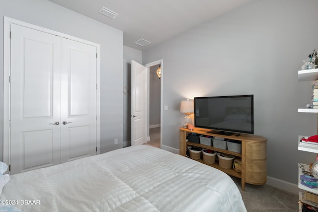 bedroom with light colored carpet and a closet