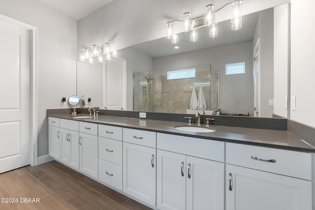 bathroom featuring hardwood / wood-style floors, vanity, and a tile shower